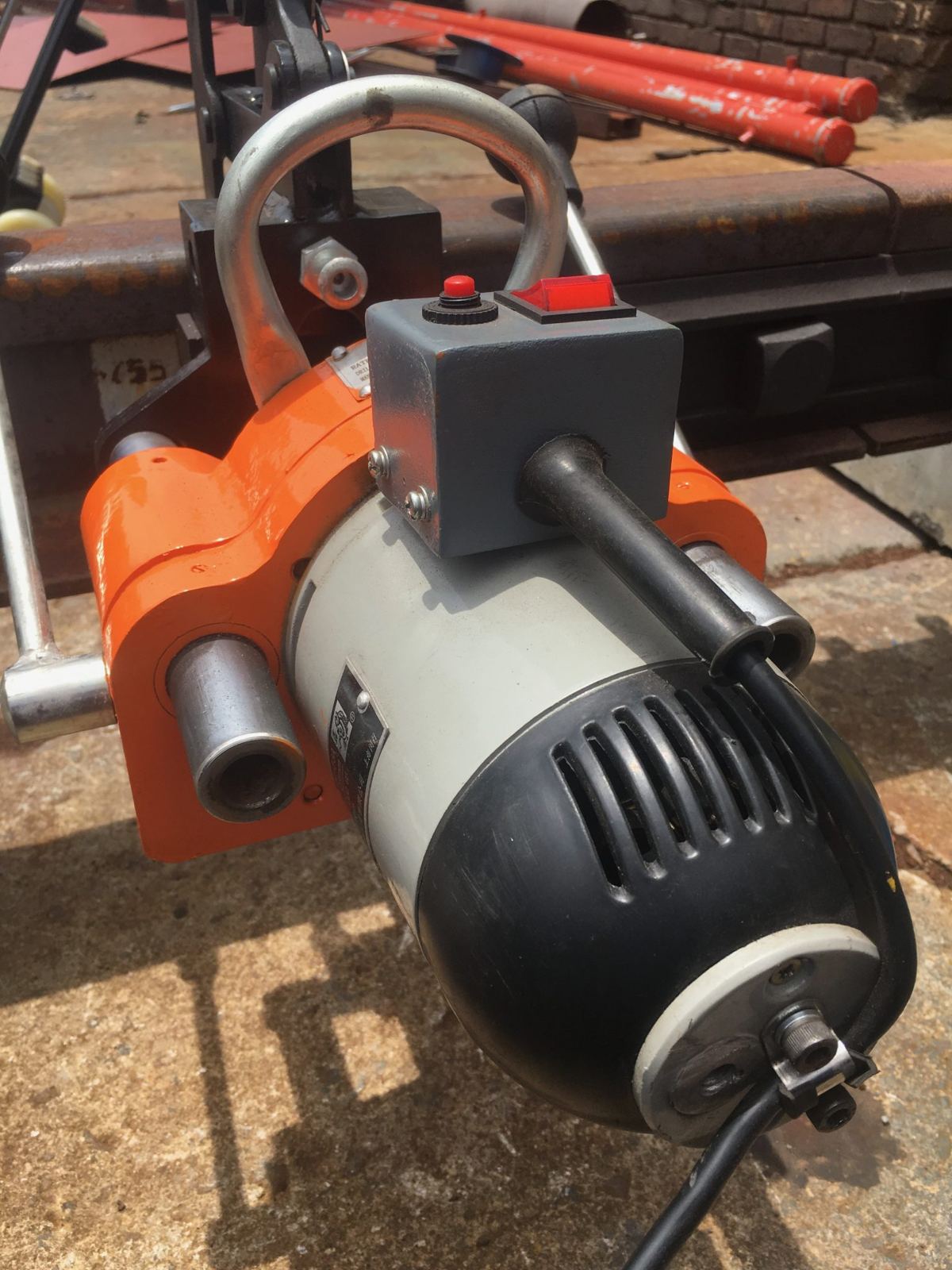Electric rail drill clamped to the rail